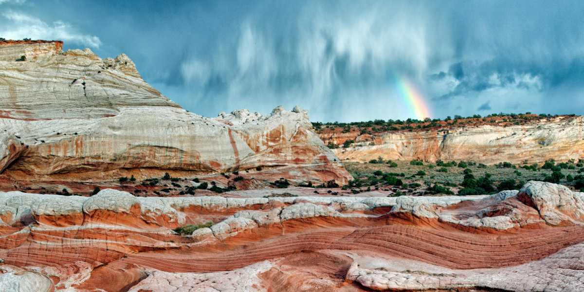 White and red sandstone formations with a rainbow in the background