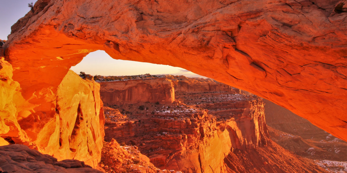 Sunset on a natural arch with a sweeping vista beyond