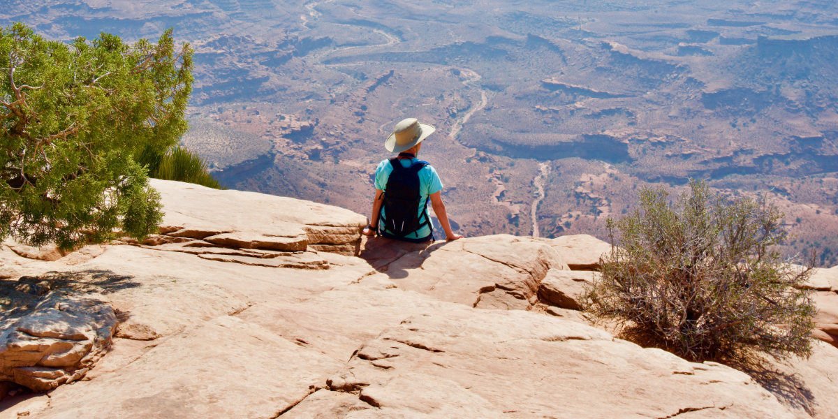 A man overlooks a distant canyon